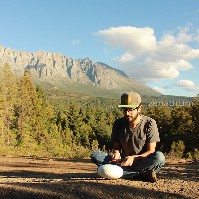 man playing tongue drum instrument, steel tongue drum play in nature